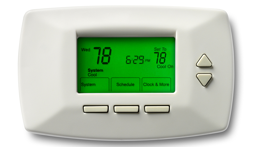 A digital thermostat with a green screen shows the set temperature at 78 degrees. The screen displays Wednesday, 6:29 p.m., and "Cool" activated. Below the screen, there are buttons labeled *System*, *Scheduling*, *Clock*, and *More*, as well as two triangular buttons for adjustments.
